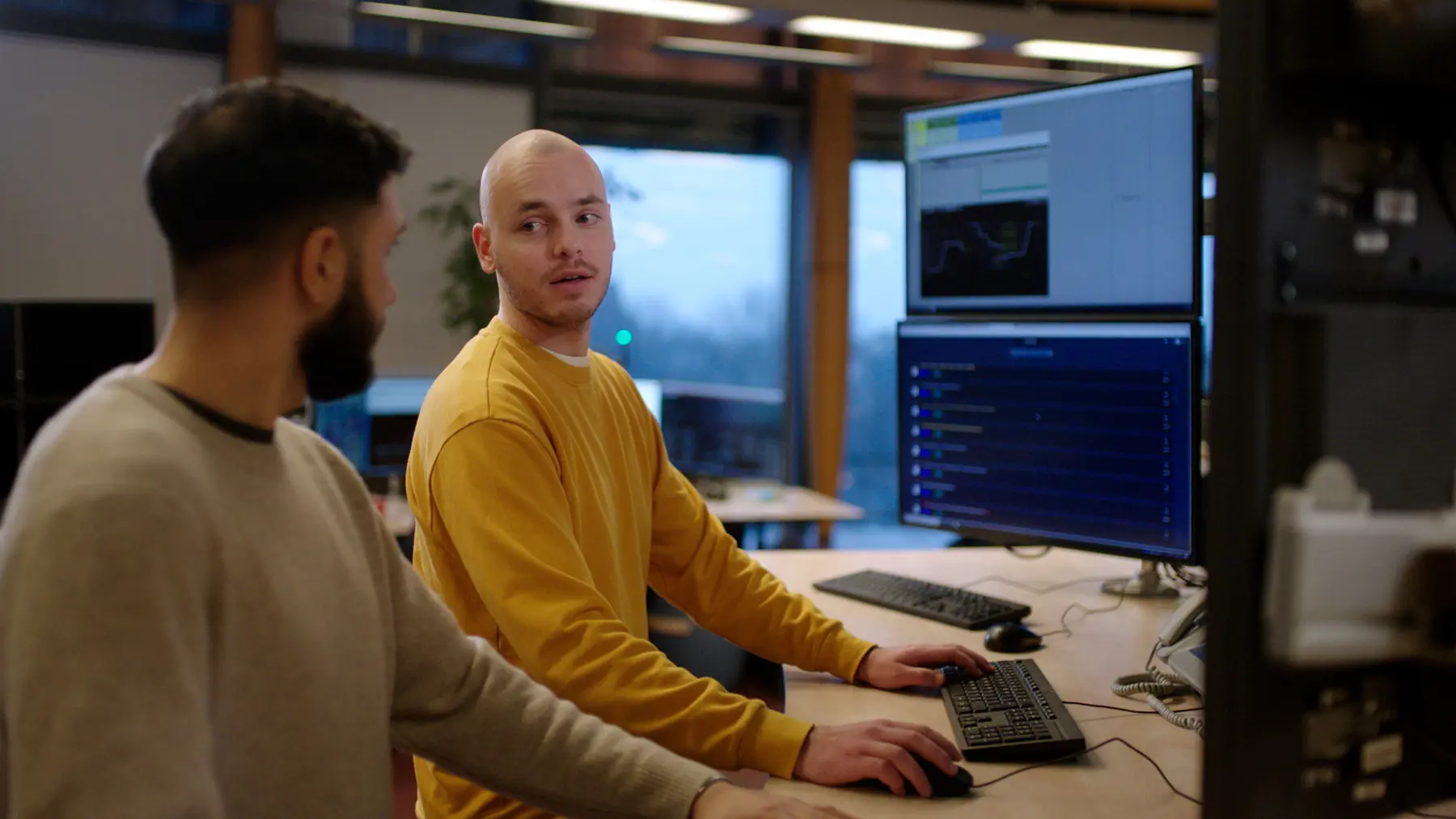 Ian in gesprek met collega aan het bureau op de post