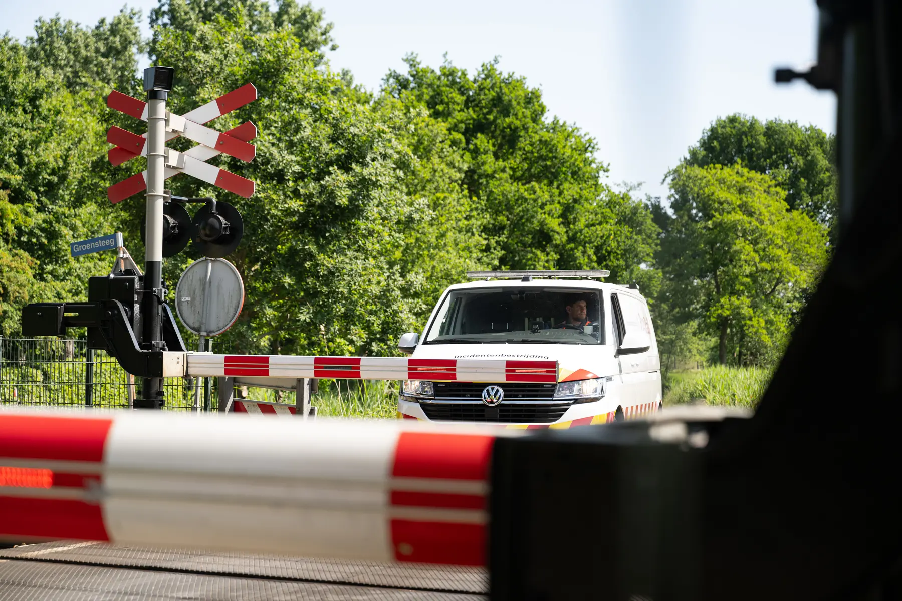 Er staat een Incidentenbestrijdingbusje van ProRail te wachten voor een spoorwegovergang, omdat de slagbomen naar beneden zijn. In het busje zit Lucas Warmenhoven, stagiair bij ProRail van team Incidentenbestrijding. 